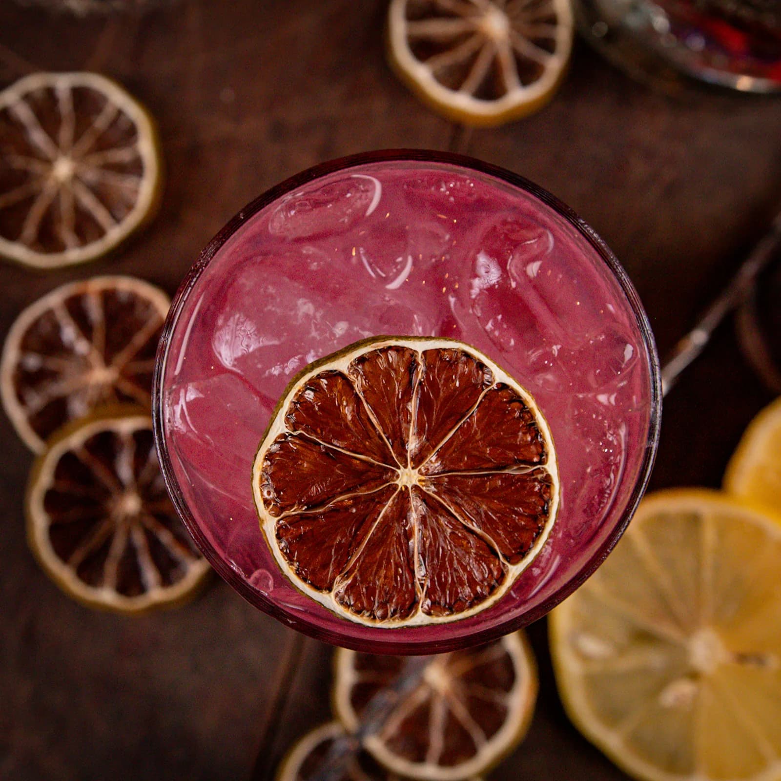 Drink rosado com rodela de limão desidratado, visto de cima