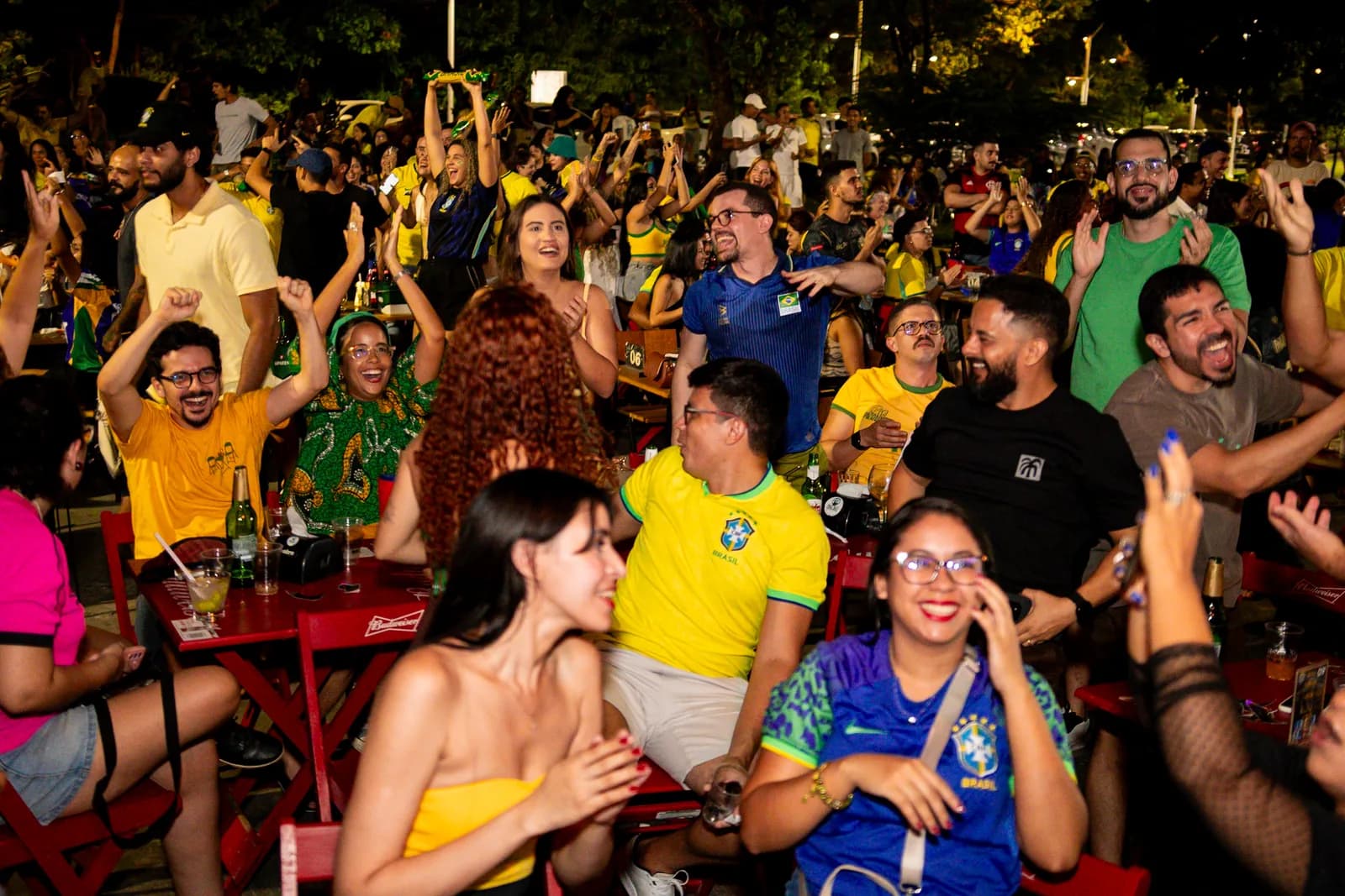 Multidão sorrindo e comemorando na área externa